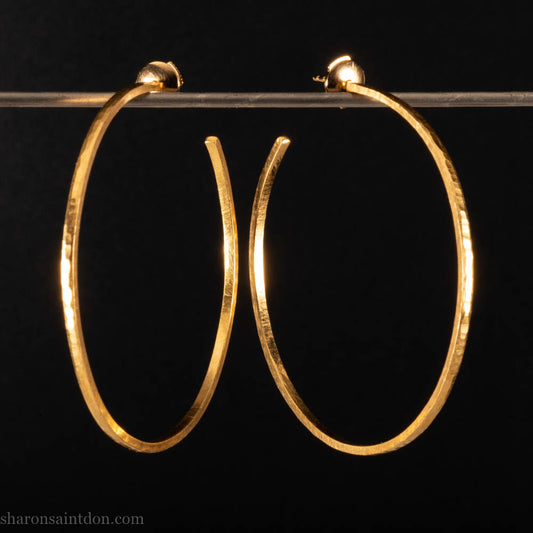 Solid 22k yellow gold hoop earrings for women. 55mm diameter, 1.5mm wide, 18k posts and locking backs. Handmade in the USA by Sharon Saint Don. Solid hammered yellow gold with sparkly, matte, brushed finish.