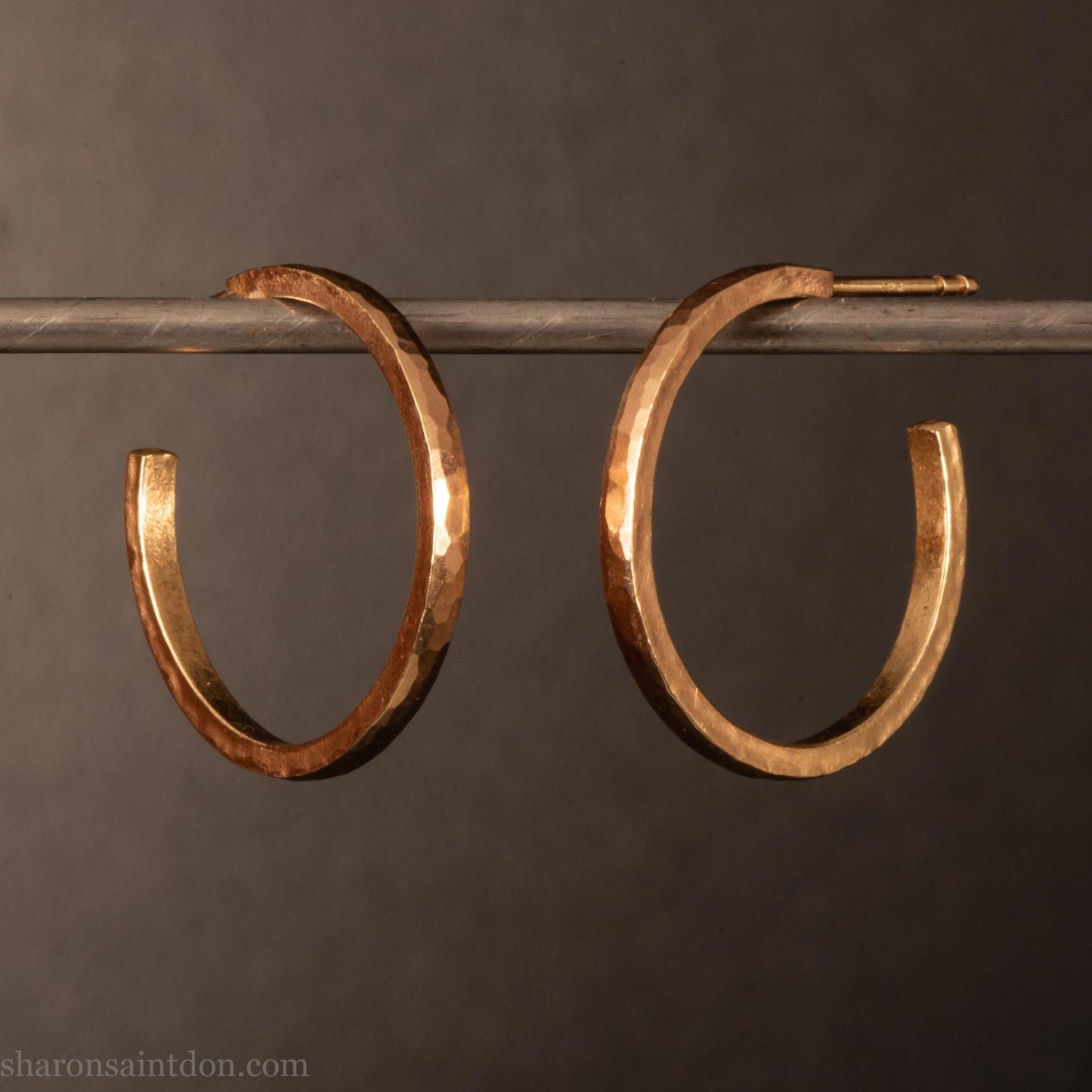 20mm diameter by 1.5mm thick solid 14k yellow gold hoop earrings. Solid 14k gold posts and backs. Handmade by Sharon SaintDon in North America. Hammered from solid gold with a matte finish.
