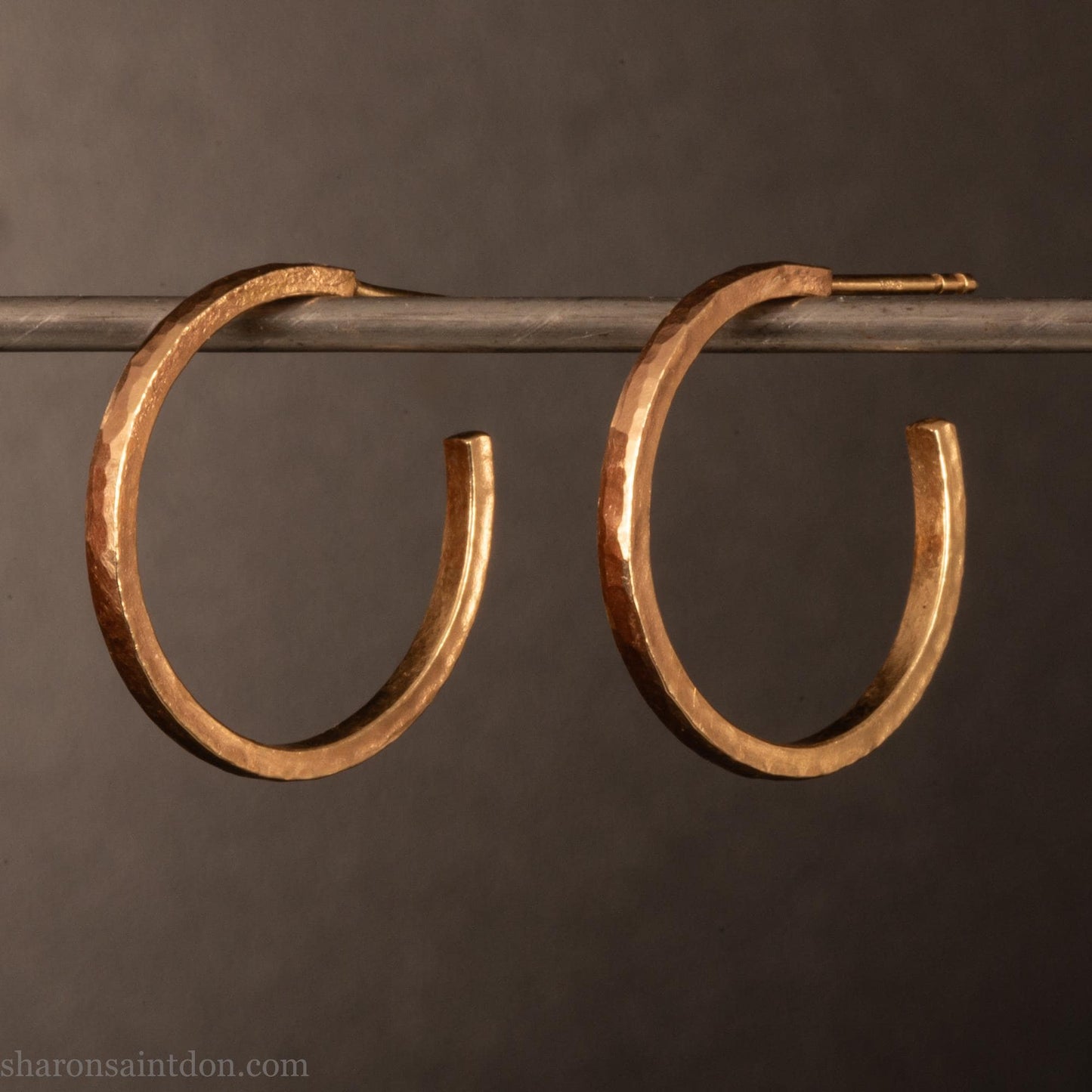 20mm diameter by 1.5mm thick solid 14k yellow gold hoop earrings. Solid 14k gold posts and backs. Handmade by Sharon SaintDon in North America. Hammered from solid gold with a matte finish.