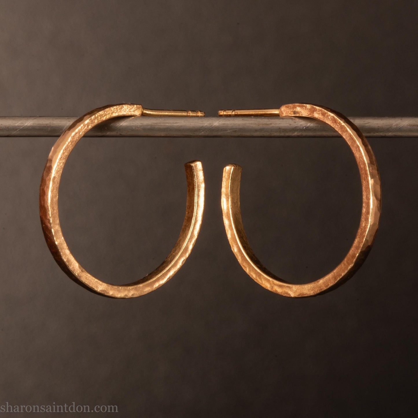 20mm diameter by 1.5mm thick solid 14k yellow gold hoop earrings. Solid 14k gold posts and backs. Handmade by Sharon SaintDon in North America. Hammered from solid gold with a matte finish.