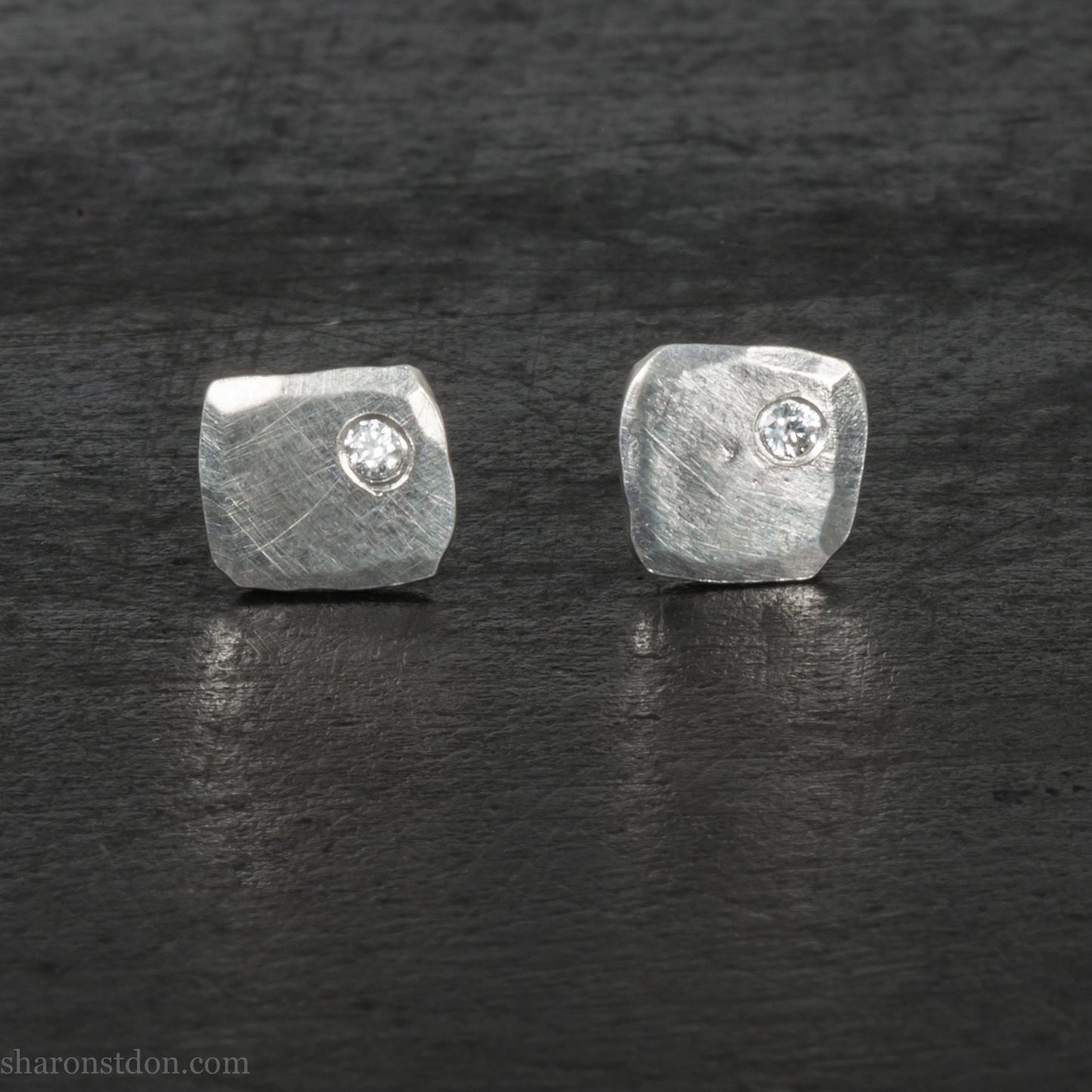 7mm square 925 sterling silver stud earrings with a 2 millimeter Canadian diamond gemstone in the corner. Hammered texture with a matte, shiny finish. Handmade by Sharon SaintDon in North America.