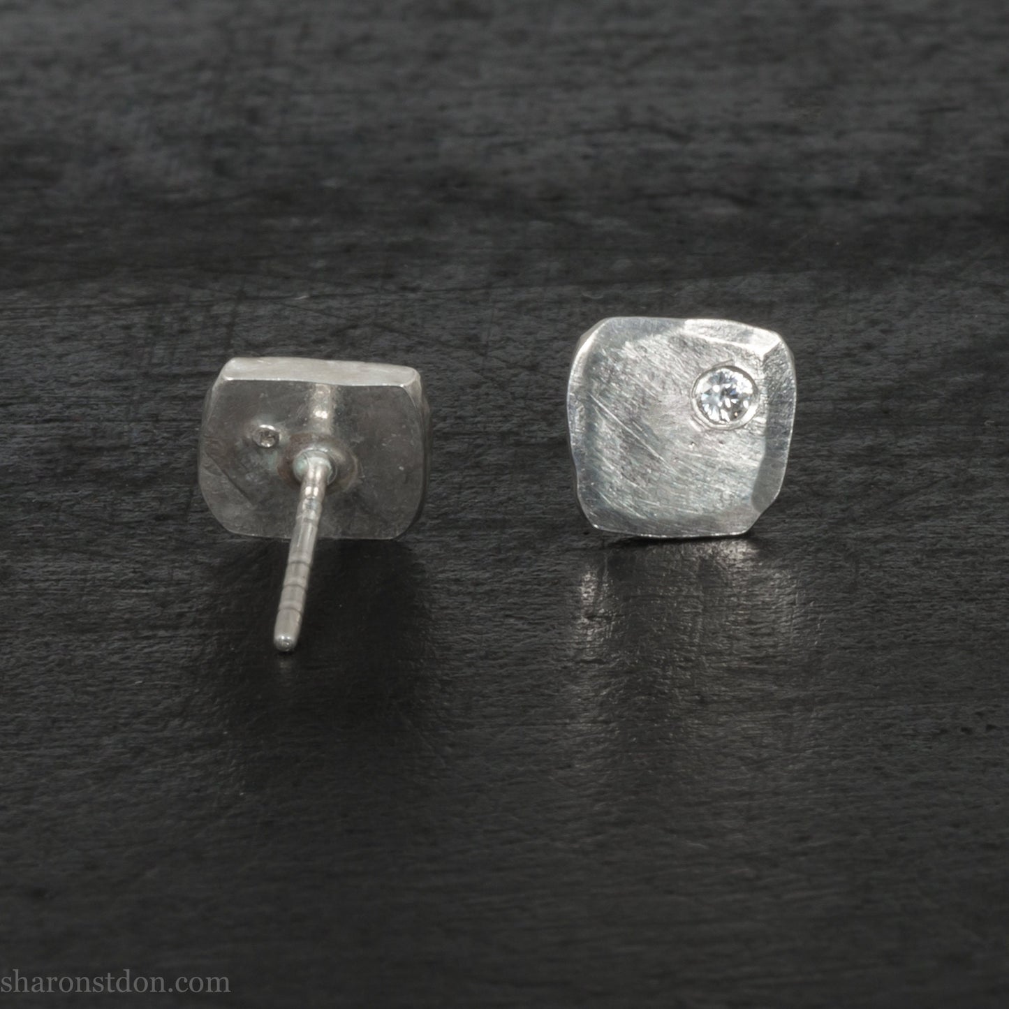 7mm square 925 sterling silver stud earrings with a 2 millimeter Canadian diamond gemstone in the corner. Hammered texture with a matte, shiny finish. Handmade by Sharon SaintDon in North America.