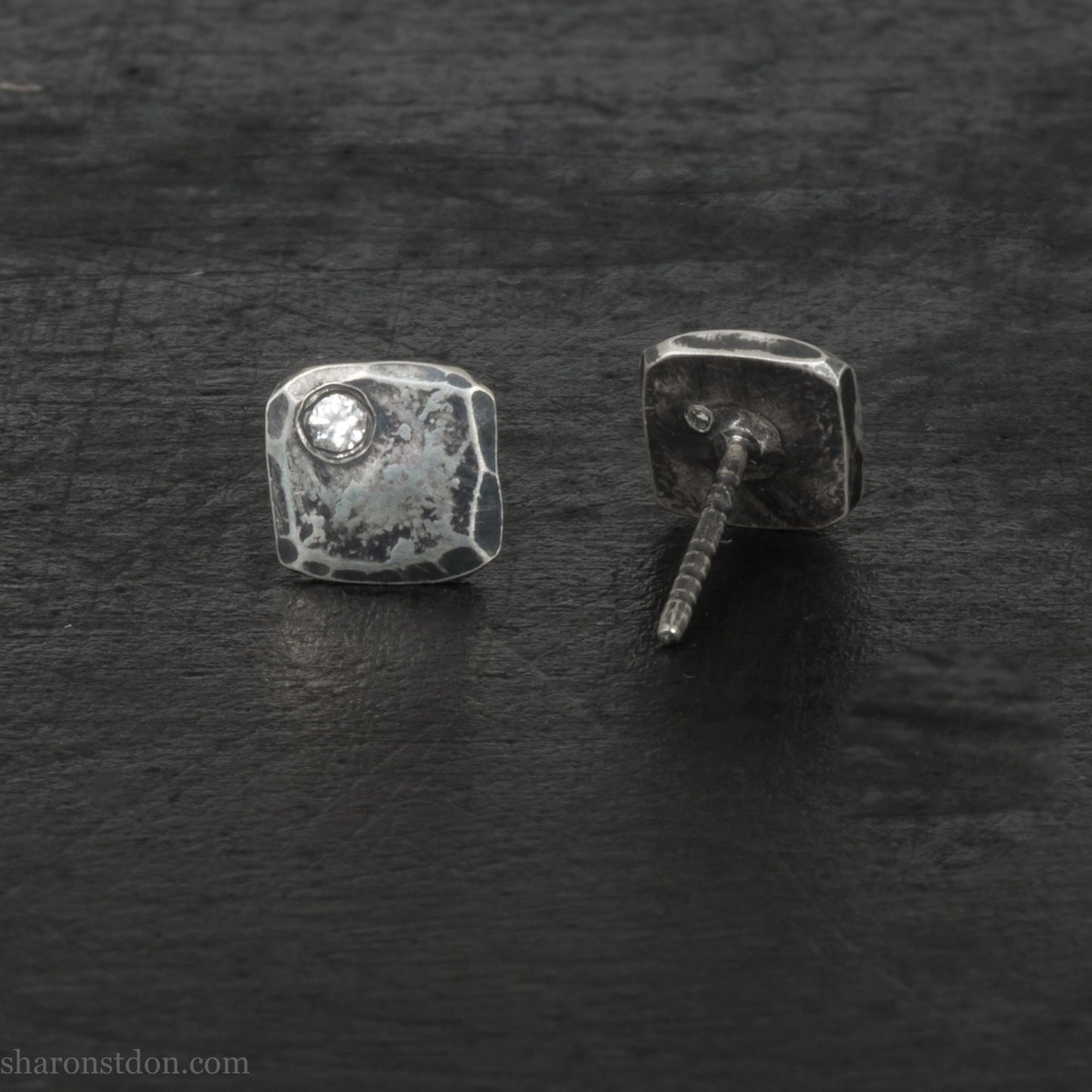 Small 925 sterling silver stud earrings for men with 2mm, imitation diamond gemstone set in the corner. 7mm square, 1.5mm thick with silver posts and backs and hammered, dark, antiqued finish. Handmade by Sharon SaintDon in North America.