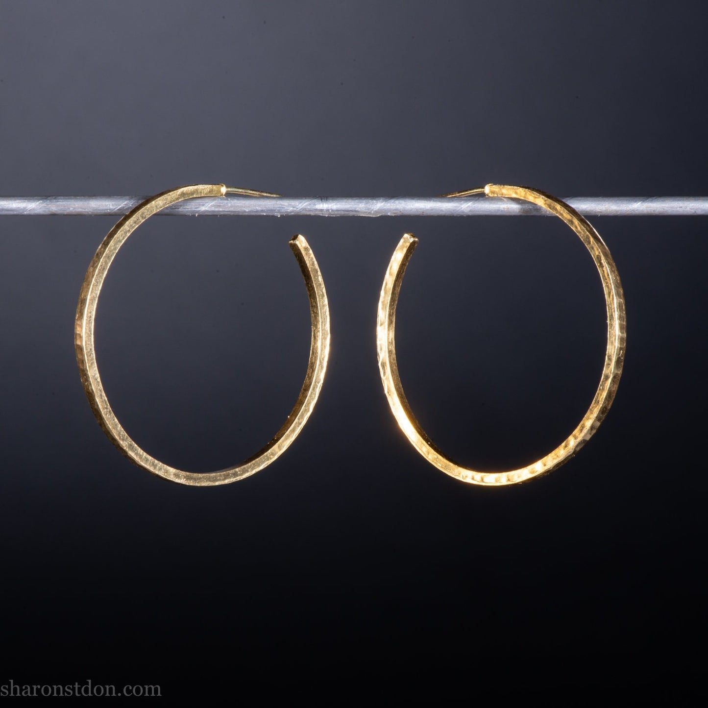 40mm diameter by 1.5mm thick handmade solid 18k yellow gold hoop earrings. Handmade by Sharon SaintDon in North America. Hammered from solid gold with a matte finish.