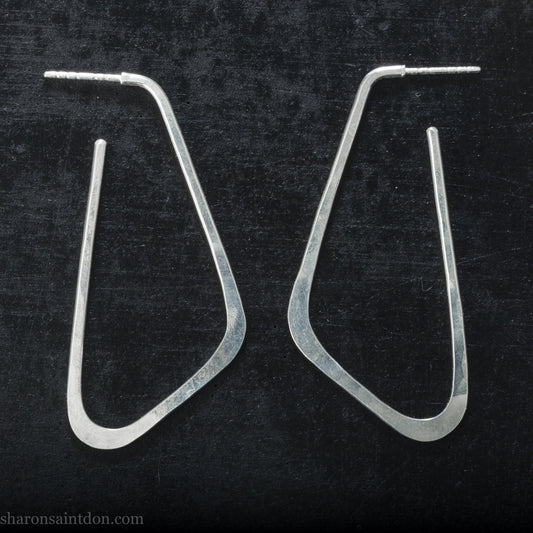Handmade 925 sterling silver hoop earrings for women. Comfortable, lightweight, daily wear earrings with a hammered texture. Size is 5cm high x 2cm wide, like a letter D with the bump below half way down. Solid silver backs and posts, and a matte shiny finish.
