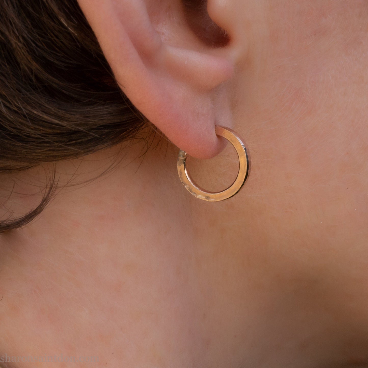 16mm diameter sold hoop earrings set handmade in North America by Sharon SaintDon. Hammered solid yellow gold, 2mm wide, 1.5mm thick, with 14k gold posts and locking backs.