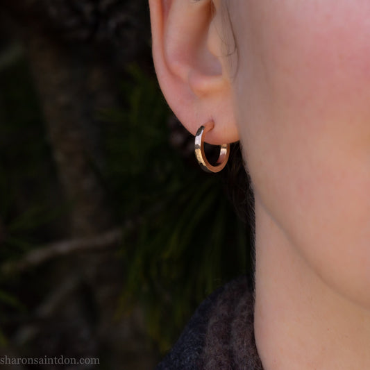 16mm diameter sold hoop earrings set handmade in North America by Sharon SaintDon. Hammered solid yellow gold, 2mm wide, 1.5mm thick, with 14k gold posts and locking backs.