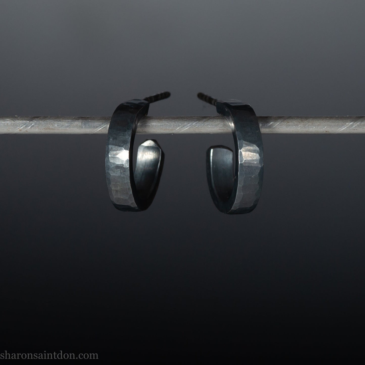 Handmade 925 sterling silver hoop earrings for men or women. 16mm x 3mm, round, oxidized black earrings with hammered texture, made by Sharon SaintDon in North America.