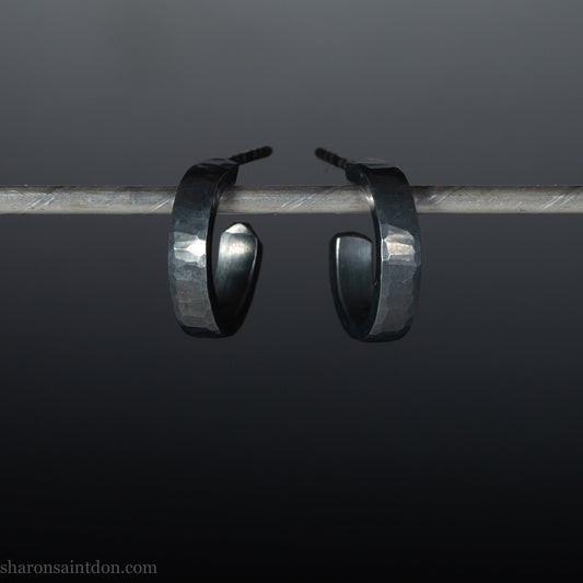 Handmade 925 sterling silver hoop earrings for men or women. 16mm x 3mm, round, oxidized black earrings with hammered texture, made by Sharon SaintDon in North America.