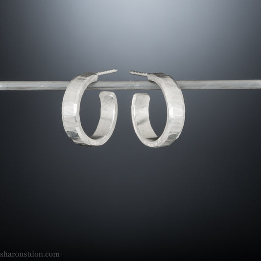18mm x 4mm small sterling silver hoop earrings for for men or women, unisex. Handmade in North America by Sharon SaintDon. Hammered texture, solid silver with silver posts and backs.