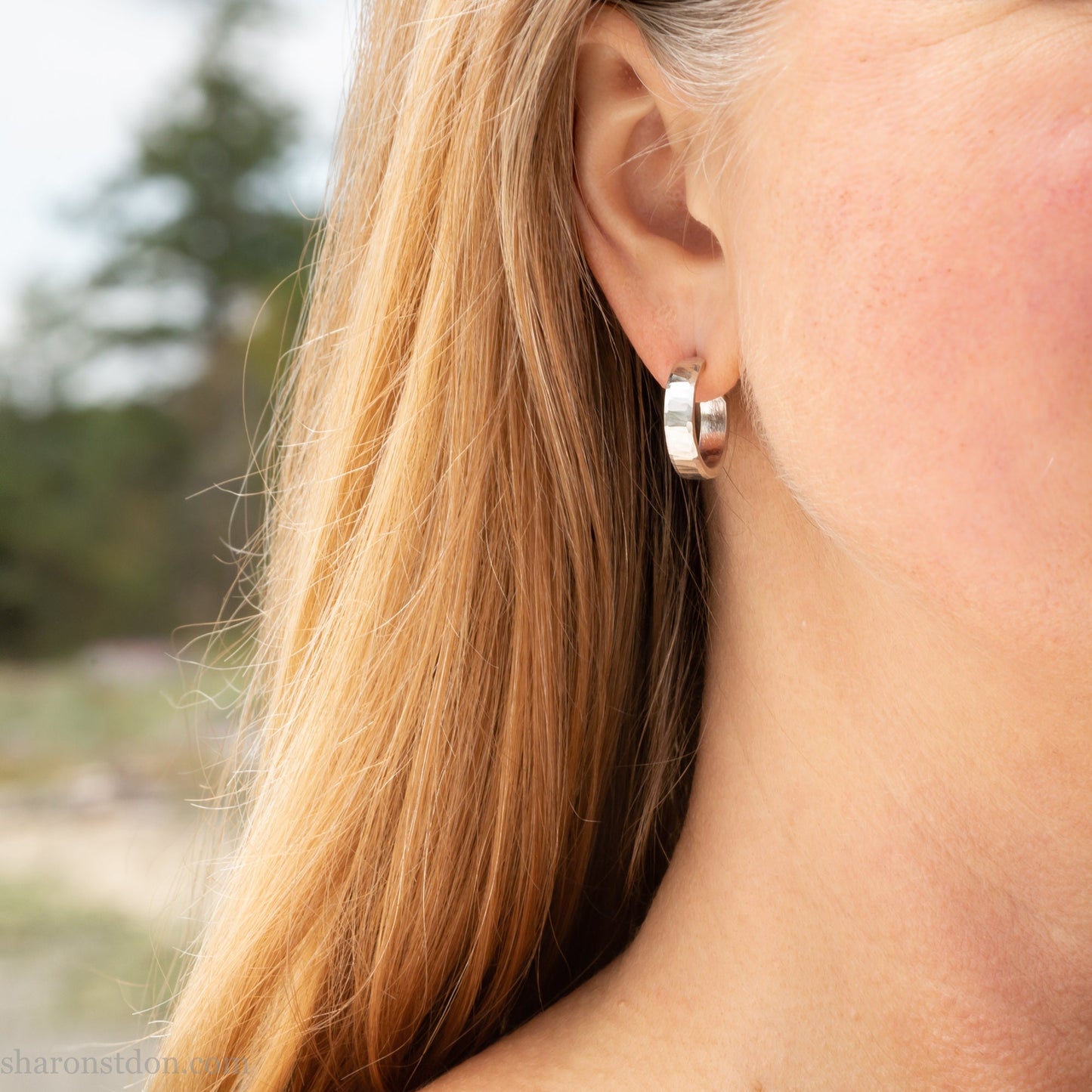 Small sterling silver hoop earrings, Handmade in North America by Sharon SaintDon. 18 x 4 x 1.5mm thick. Solid hammered silver with a matte, brushed finish, silver posts and backs.