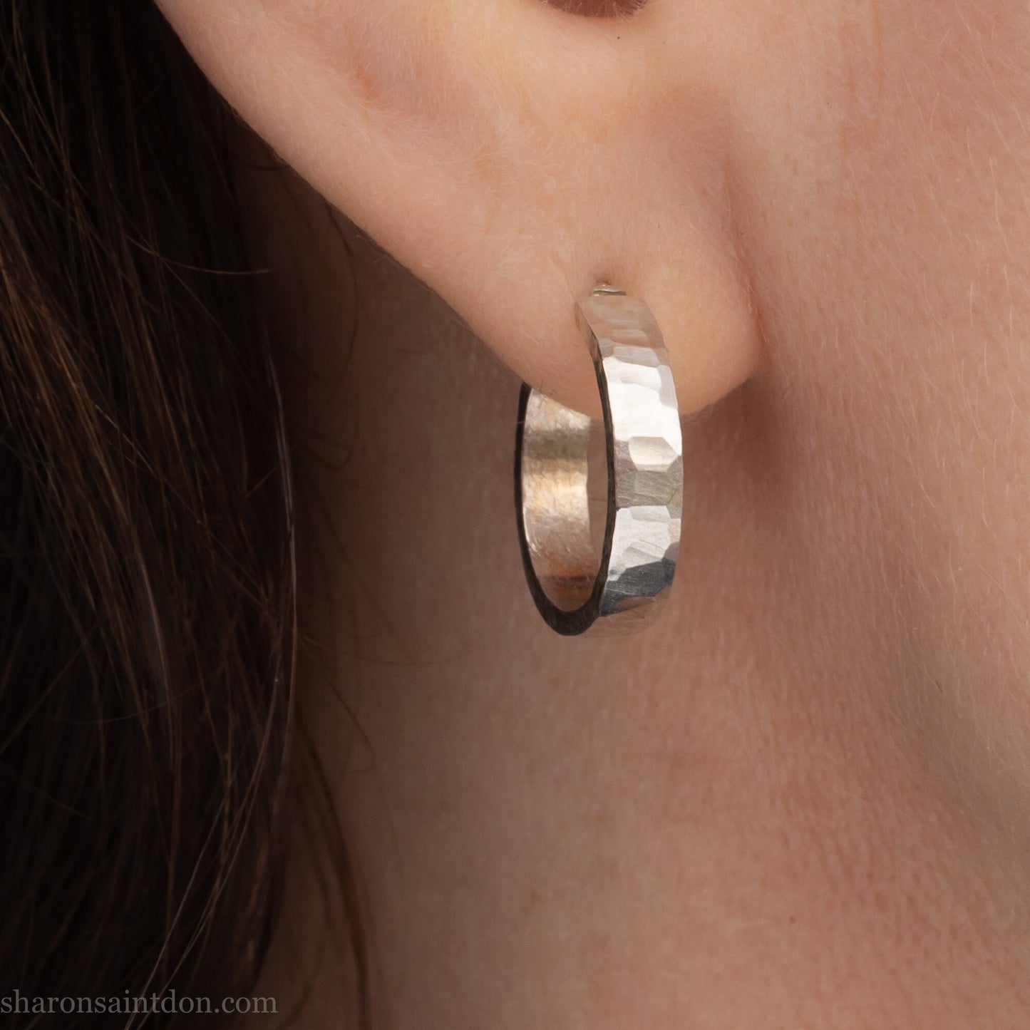 Small sterling silver hoop earrings, Handmade in North America by Sharon SaintDon. 18 x 4 x 1.5mm thick. Solid hammered silver with a matte, brushed finish, silver posts and backs.