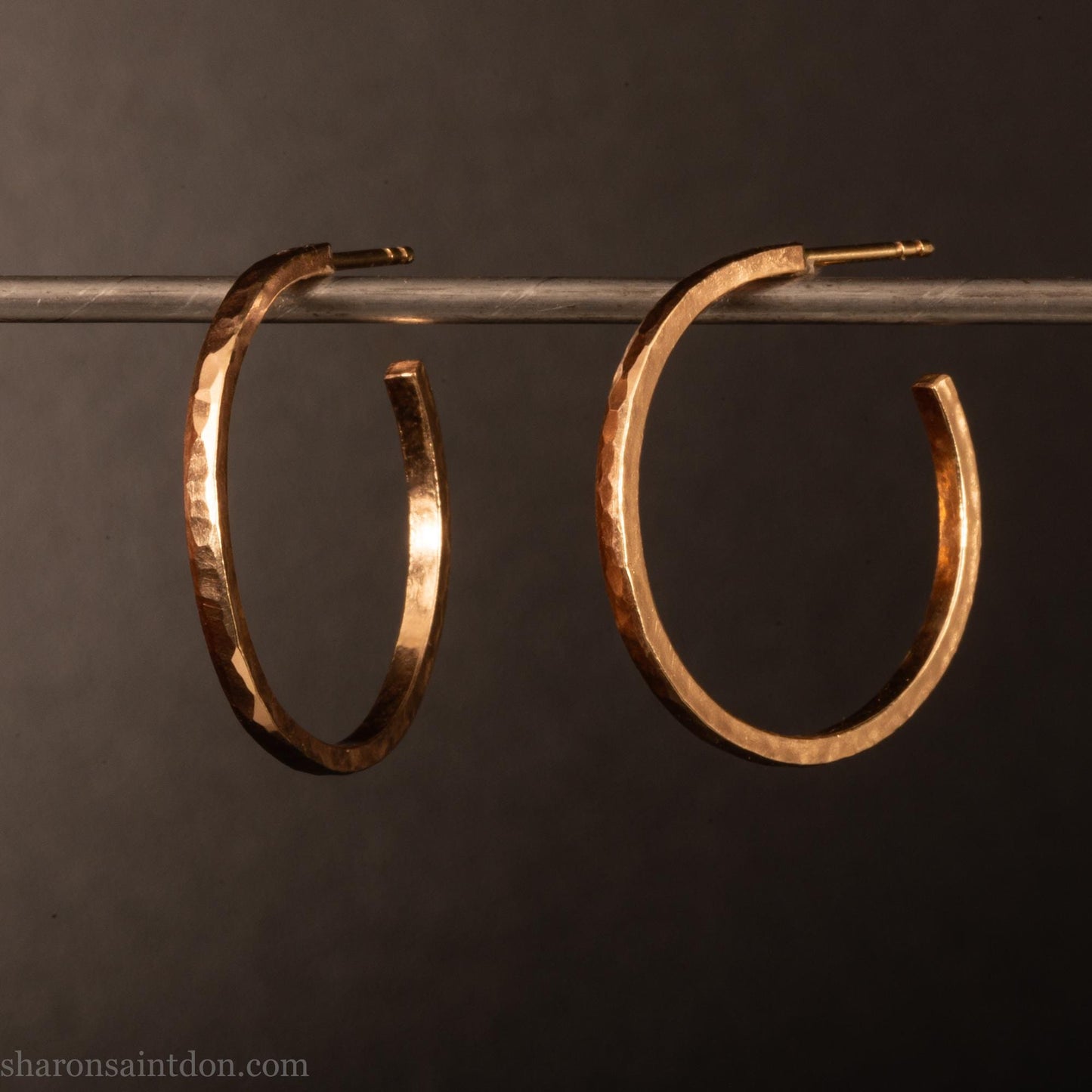 25mm diameter by 1.5mm thick solid 14k yellow gold hoop earrings. Solid 14k gold posts and backs. Handmade by Sharon SaintDon in North America. Hammered from solid gold with a matte finish.