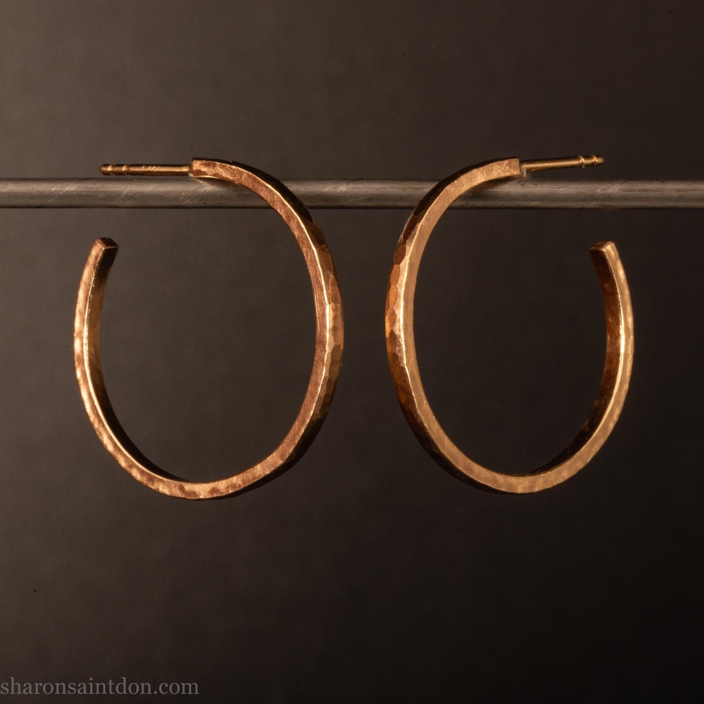 25mm diameter by 1.5mm thick solid 14k yellow gold hoop earrings. Solid 14k gold posts and backs. Handmade by Sharon SaintDon in North America. Hammered from solid gold with a matte finish.
