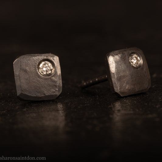 Handcrafted 7mm square sterling silver stud earrings, oxidized black with a 2mm round moissanite gemstone set in the corner.