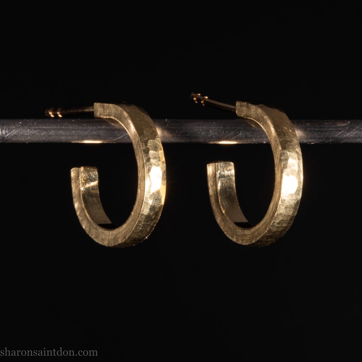 Hammered solid 18k yellow gold hoop earrings. 18mm diameter, 2mm wide, with a matte, brushed finish. Solid 18k gold posts and locking backs. Handmade by Sharon SaintDon in North America.