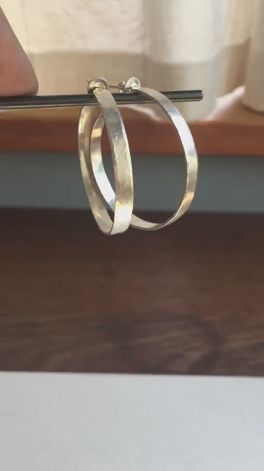 Solid 925 sterling silver hoop earrings. 40mm diameter, 5mm wide, .75 thick. Hammered texture, silver posts and backs. Handmade in USA by Sharon Saint Don.