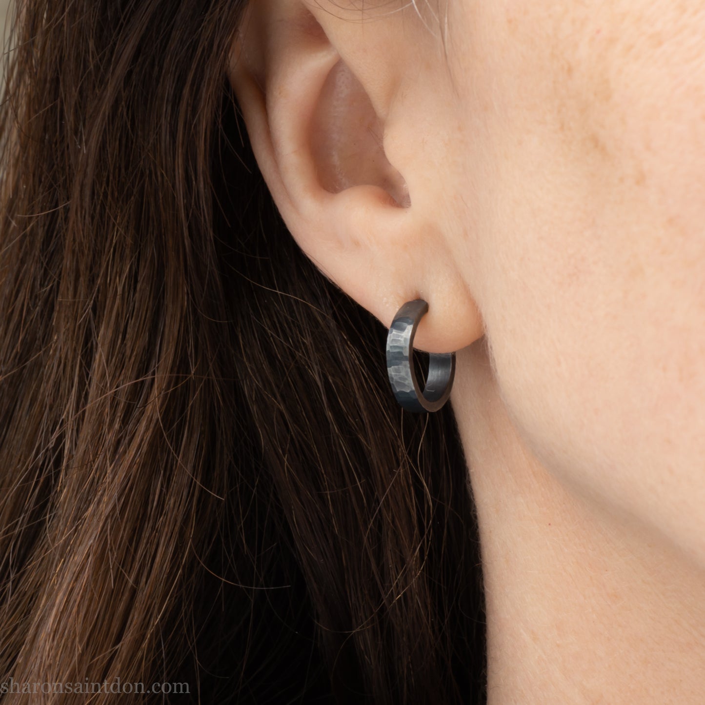 18mm x 4mm small sterling silver hoop earrings for for men or women, unisex. Handmade in North America by Sharon SaintDon. Hammered texture,solid silver with silver posts and backs oxidized black minimalist earrings