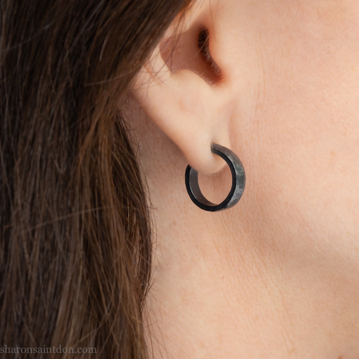 18mm x 4mm small sterling silver hoop earrings for for men or women, unisex. Handmade in North America by Sharon SaintDon. Hammered texture,solid silver with silver posts and backs oxidized black minimalist earrings