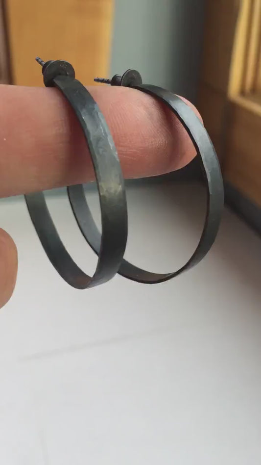 925 sterling silver hoop earrings for women. Hammered, solid silver, oxidized black with silver posts and backs. 40mm diameter, 5mm wide, .75mm thick, comfortable, lightweight. Handmade by Sharon SaintDon in Pacific Northwest, North America.