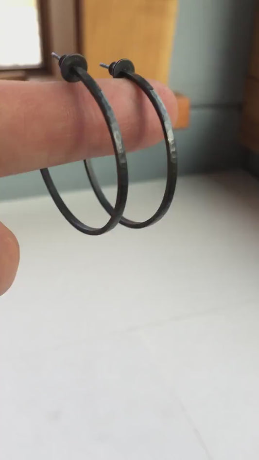 Handmade 925 sterling silver hoop earrings. 40mm diameter, 2mm wide, 1mm thick. Hammered solid sterling silver, oxidized black with silver posts and backs. Comfortable, lightweight, daily wear earrings handmade by Sharon SaintDon in North America.