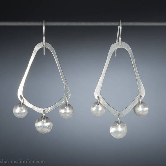 925 sterling silver handcrafted earrings. A hammered, angular, teardrop loop with three dots hanging from the angled teardrop points. Size: 60mm high to top of hook x 35mm at widest point, dots approximately 1cm. Comfortable, lightweight, with handmade ear wire hooks.