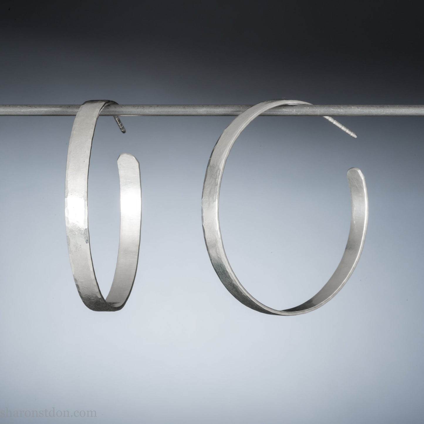 Solid large 925 sterling silver hoop earrings. Handmade by Sharon SaintDon in North America. 50mm diameter, 2mm wide, 1.5mm thick, Brushed, matte finish and silver posts and backs.
