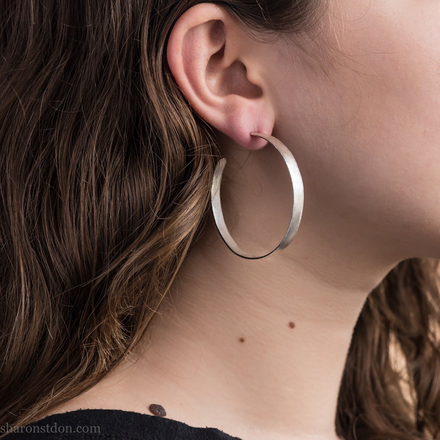 Solid large 925 sterling silver hoop earrings. Handmade by Sharon SaintDon in North America. 50mm diameter, 2mm wide, 1.5mm thick, Brushed, matte finish and silver posts and backs.