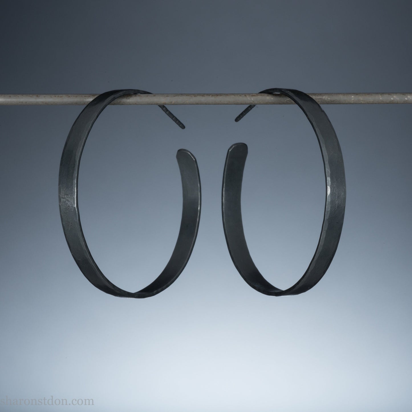 925 sterling silver hoop earrings for women. Hammered, solid silver, oxidized black with silver posts and backs. 40mm diameter, 5mm wide, .75mm thick, comfortable, lightweight. Handmade by Sharon SaintDon in Pacific Northwest, North America.