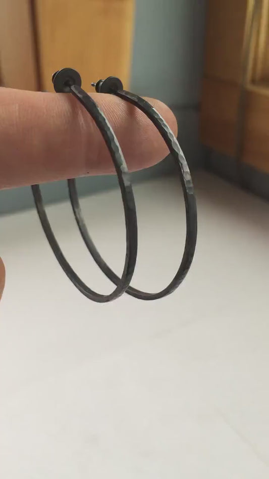Solid 925 sterling silver hoop earrings. Oxidized black, 50mm diameter, 2mm wide, 1.5mm thick. Lightweight hammered large hoop earrings handmade by Sharon SaintDon in North America.