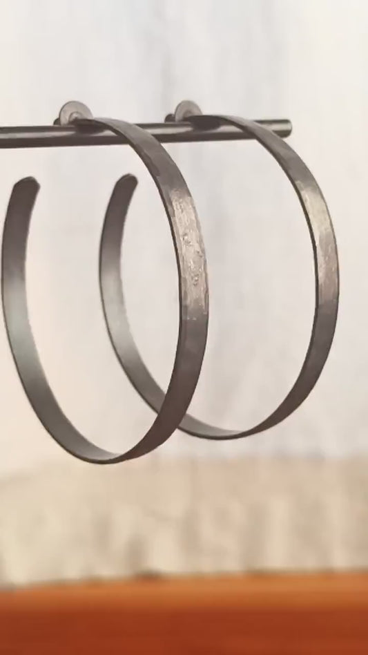 Solid 925 sterling silver hoop earrings. 50mm diameter, 5mm wide, .75mm thick. Oxidized black, charcoal grey, matte finish with silver posts and backs. lightweight, high quality, handmade by Sharon SaintDon in the Pacific Northwest of the USA.