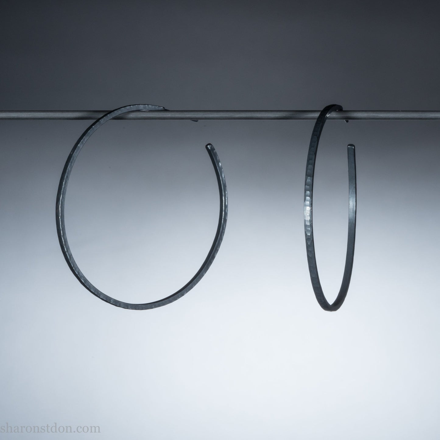Solid 925 sterling silver hoop earrings. Oxidized black, 50mm diameter, 2mm wide, 1.5mm thick. Lightweight hammered large hoop earrings handmade by Sharon SaintDon in North America.