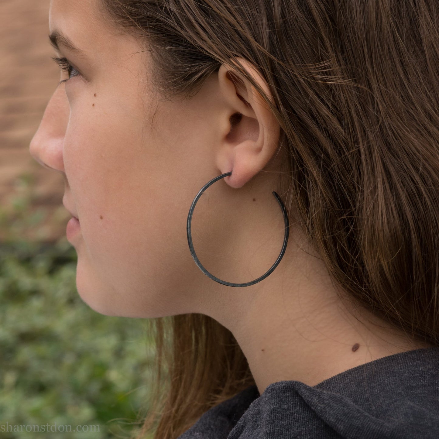 Solid 925 sterling silver hoop earrings. Oxidized black, 50mm diameter, 2mm wide, 1.5mm thick. Lightweight hammered large hoop earrings handmade by Sharon SaintDon in North America.