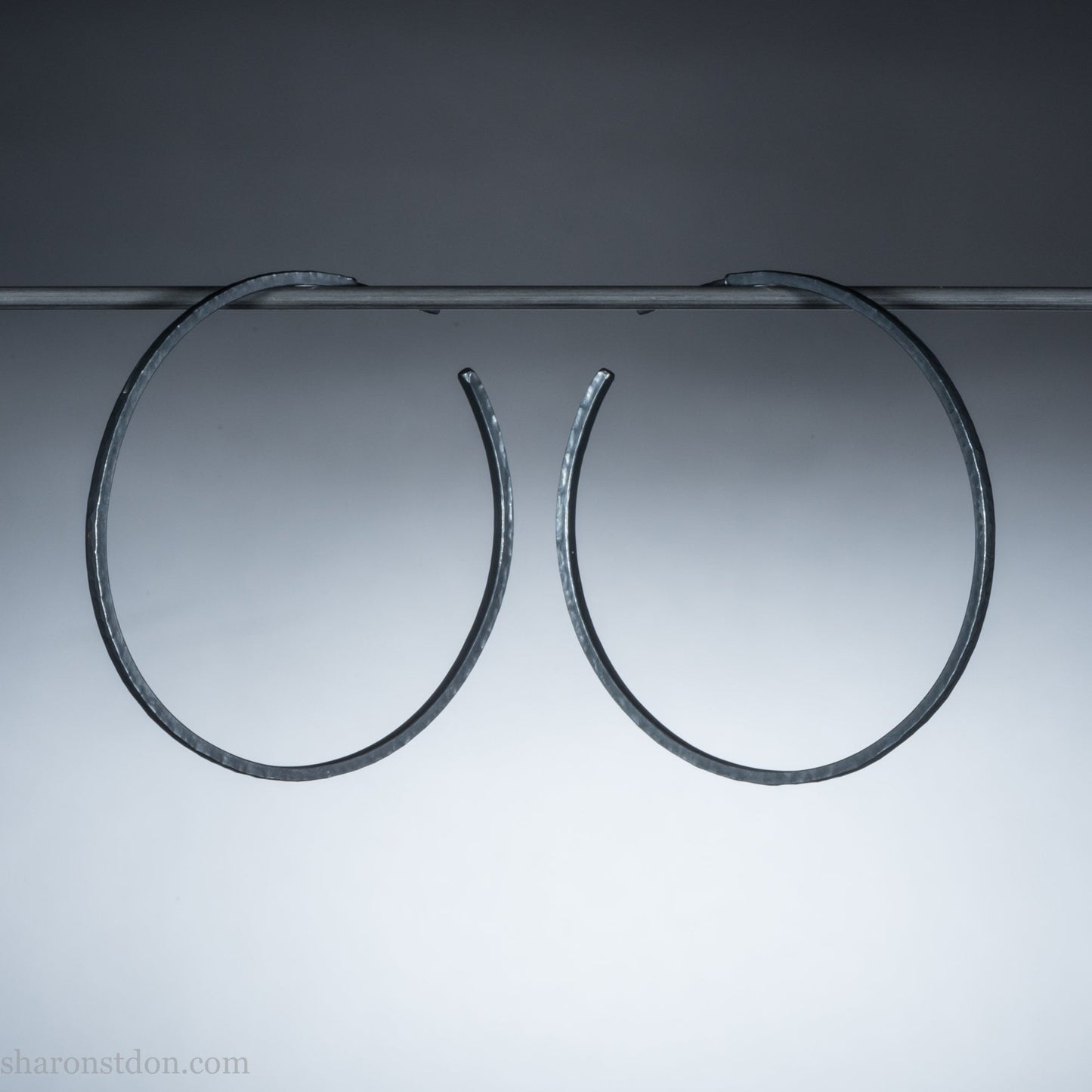 Solid 925 sterling silver hoop earrings. Oxidized black, 50mm diameter, 2mm wide, 1.5mm thick. Lightweight hammered large hoop earrings handmade by Sharon SaintDon in North America.