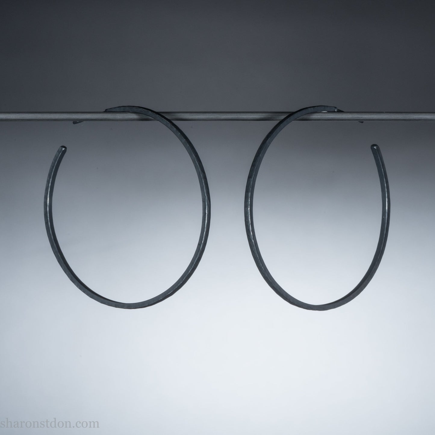 Solid 925 sterling silver hoop earrings. Oxidized black, 50mm diameter, 2mm wide, 1.5mm thick. Lightweight hammered large hoop earrings handmade by Sharon SaintDon in North America.