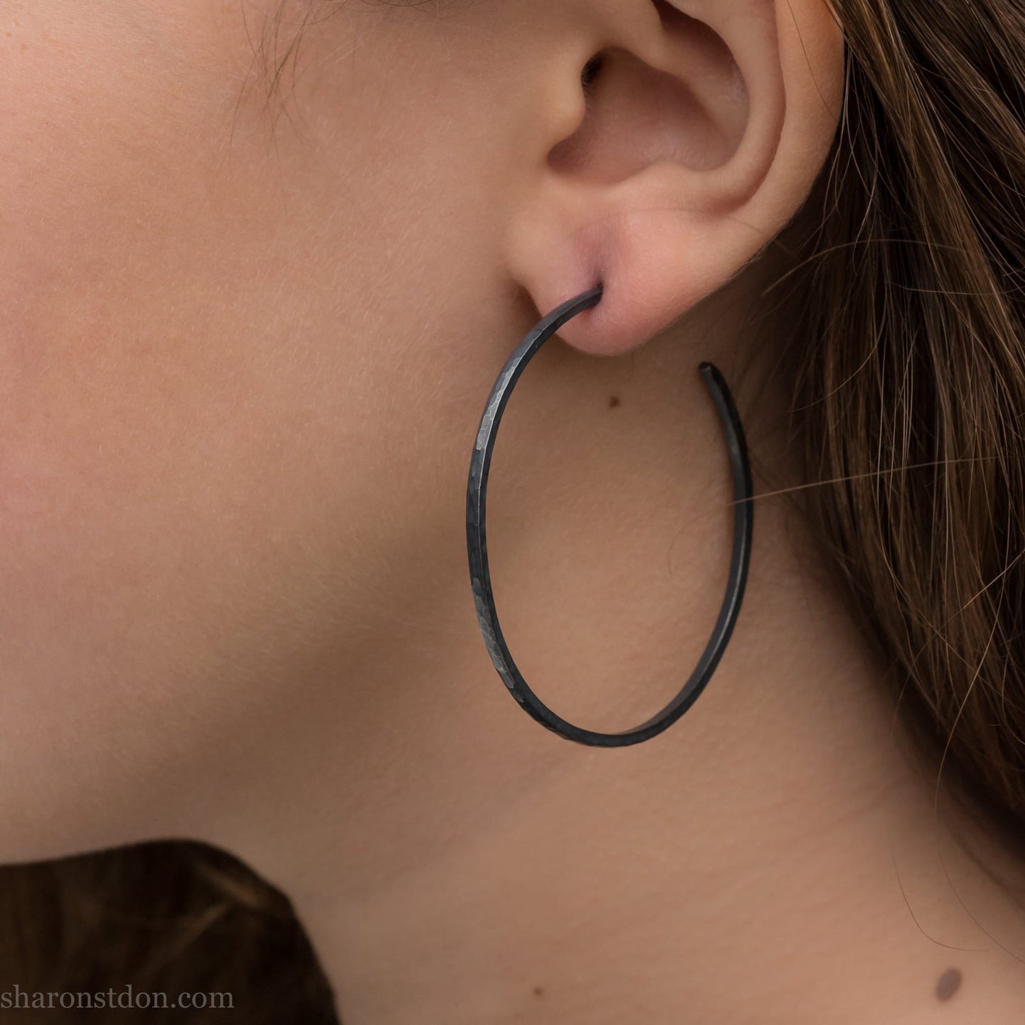Solid 925 sterling silver hoop earrings. Oxidized black, 50mm diameter, 2mm wide, 1.5mm thick. Lightweight hammered large hoop earrings handmade by Sharon SaintDon in North America.