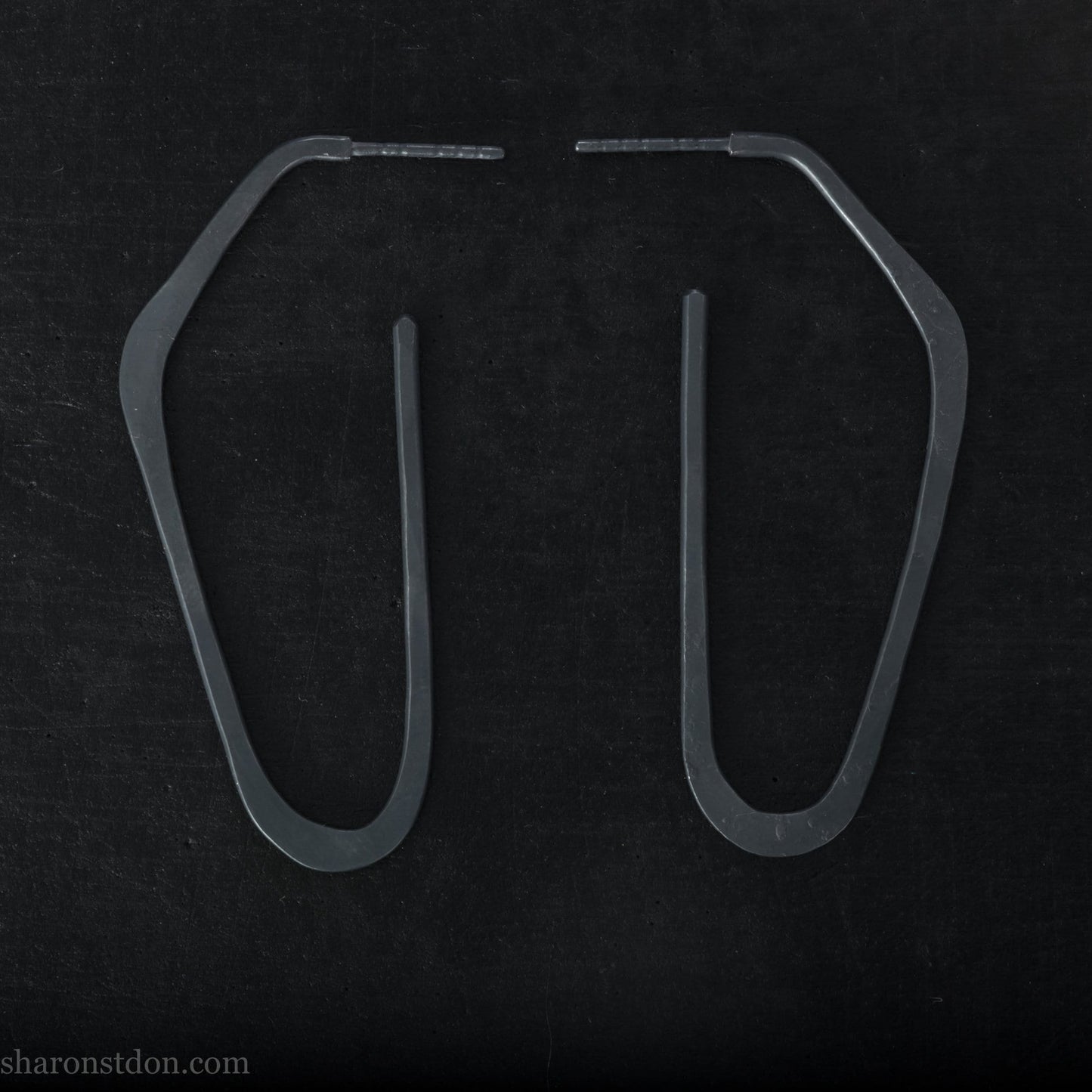 925 sterling silver hoop earrings handmade in North America by Sharon SaintDon. Long, angular, high D shape, oxidized black with hammered texture. SIZE: 47mm high x 19mm wide