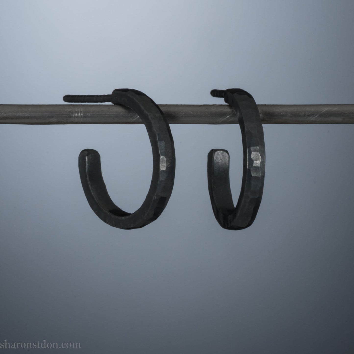 16mm x 2mm 925 sterling silver hoop earrings for men, handmade in North America by Sharon SaintDon. Oxidized black silver, small, round with hammered texture.