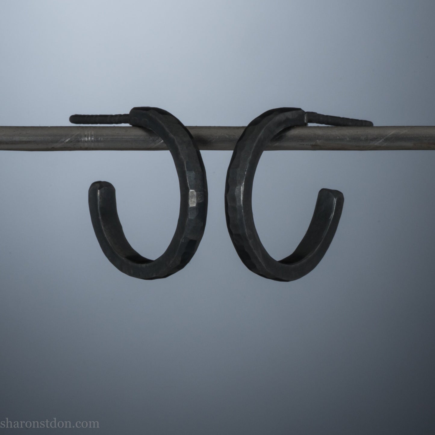 16mm x 2mm 925 sterling silver hoop earrings for men, handmade in North America by Sharon SaintDon. Oxidized black silver, small, round with hammered texture.