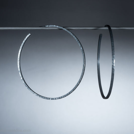 Handmade 925 sterling silver hoop earrings for women. 55mm diameter, 2mm wide, oxidized black, large hoops for daily wear. Minimalist, comfortable, lightweight with a hammered, texture.