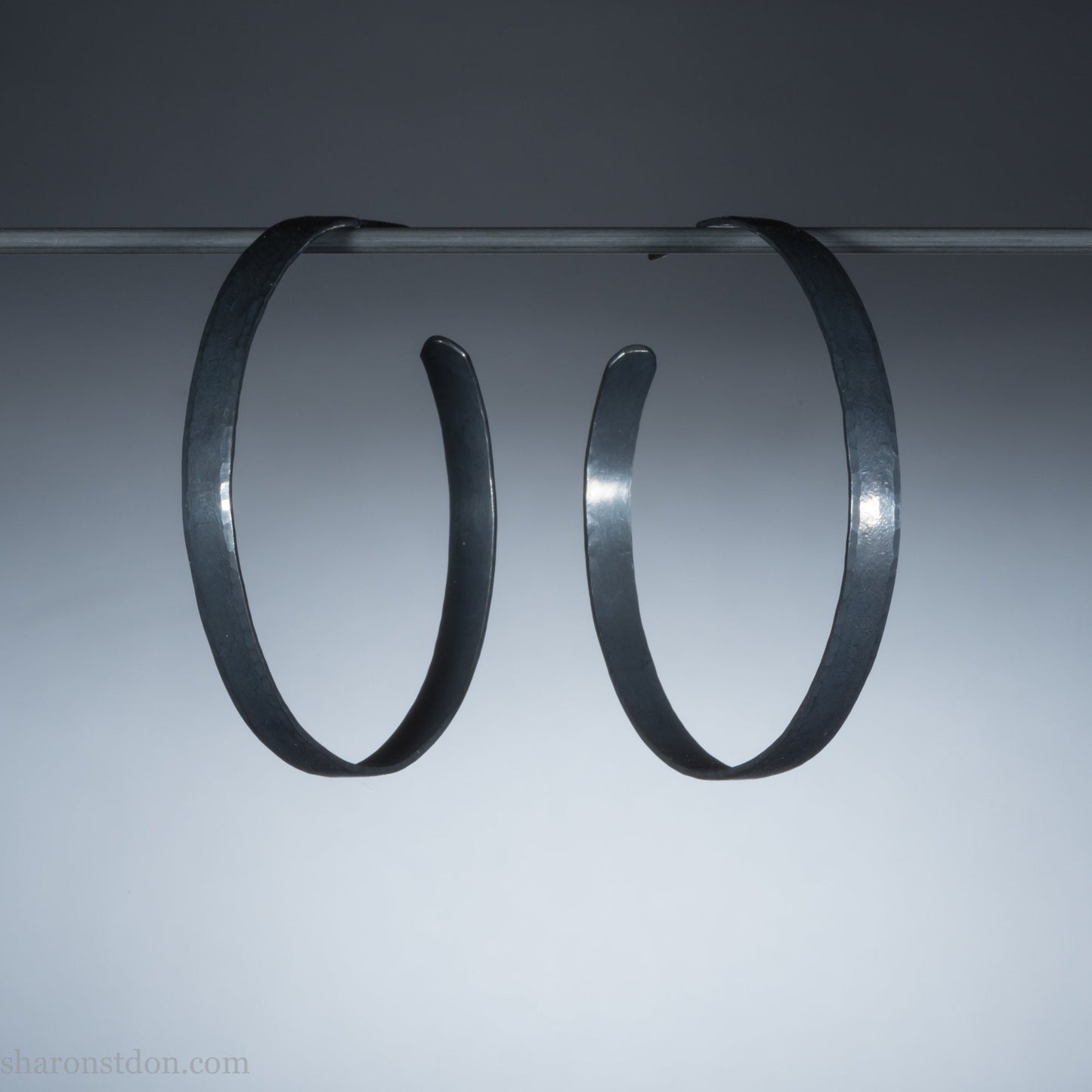 Handmade 925 sterling silver hoop earrings for women. Oxidized black, lightweight large hoop earrings handmade and hammered by Sharon SaintDon in the Pacific Northwest of the USA. 50mm diameter, 5mm wide.