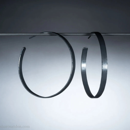 Handmade 925 sterling silver hoop earrings for women. 55mm diameter, 5mm wide, Oxidized black, large hoops for daily wear. Minimalist, comfortable, lightweight with a hammered, texture.