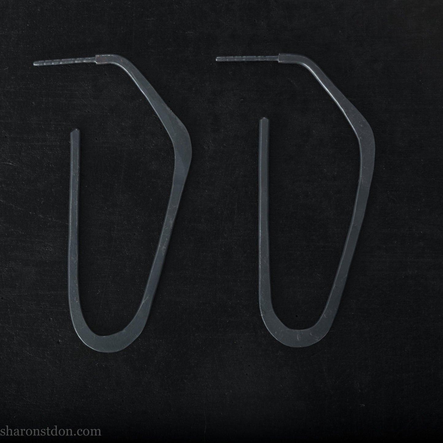 925 sterling silver hoop earrings handmade in North America by Sharon SaintDon. Long, angular, high D shape, oxidized black with hammered texture. SIZE: 47mm high x 19mm wide