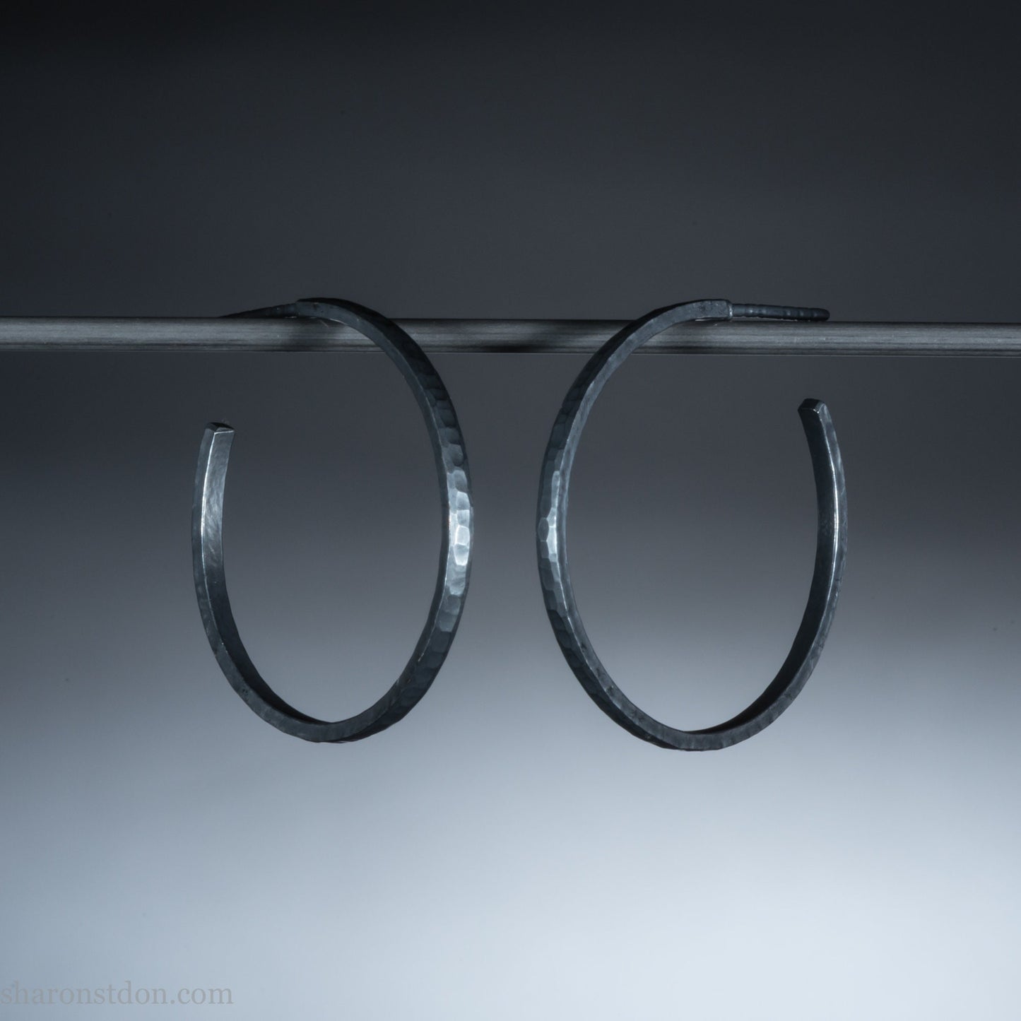 25mm x 2mm Oxidized black 925 sterling silver hoop earrings for women. Hammered solid silver hoops, handmade by Sharon SaintDon in North America.