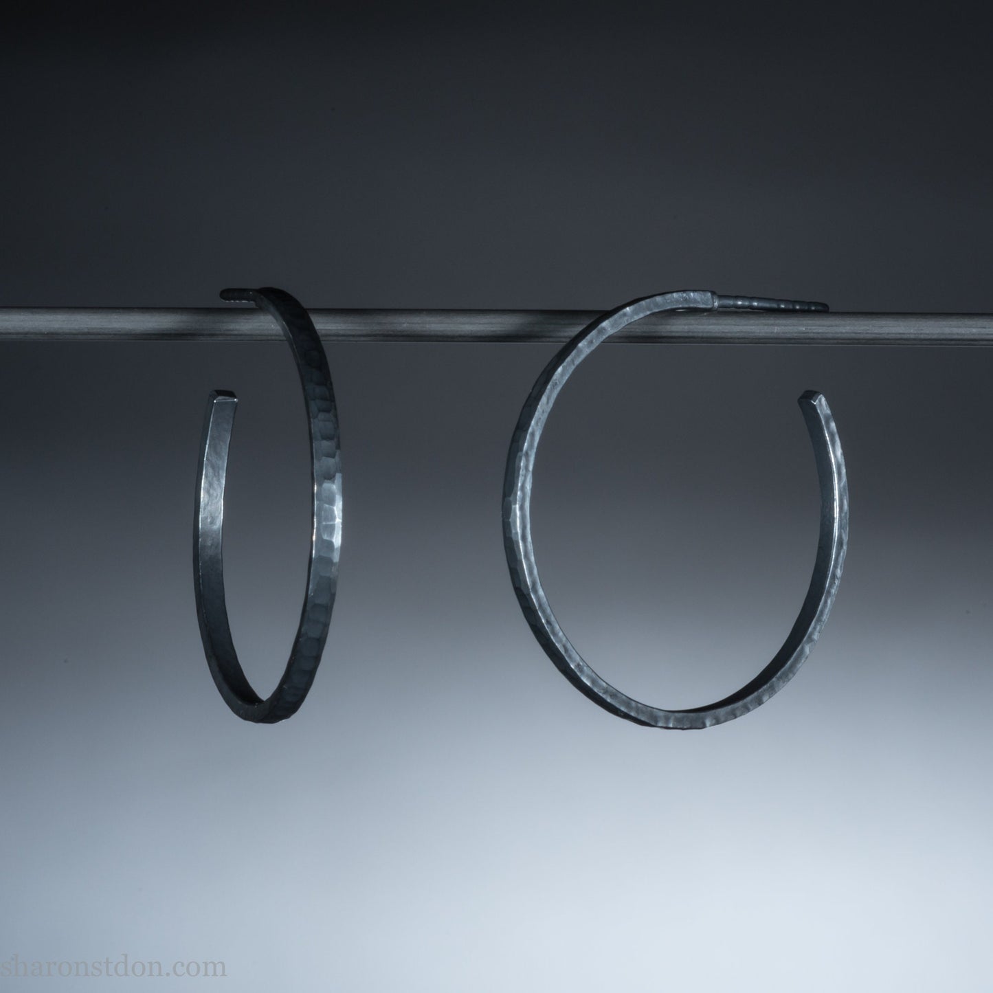 25mm x 2mm Oxidized black 925 sterling silver hoop earrings for women. Hammered solid silver hoops, handmade by Sharon SaintDon in North America.