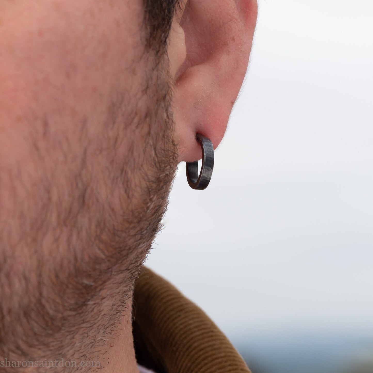 925 sterling silver hoop earrings for men or women, handmade in North America by Sharon SaintDon. 18mm diameter x 3mm wide, small, round, oxidized black with hammered texture.