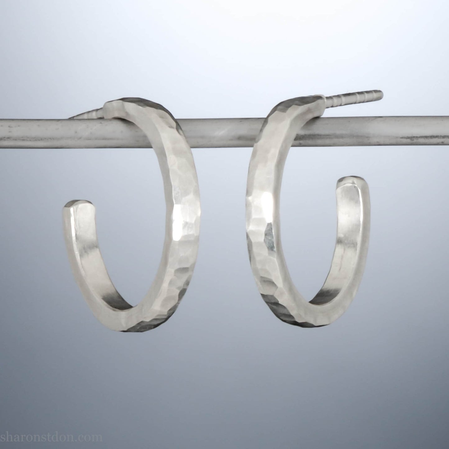 925 sterling silver hoop earrings handmade in North America by Sharon SaintDon. 18mm x 2mm, small, round, shiny, with hammered texture.