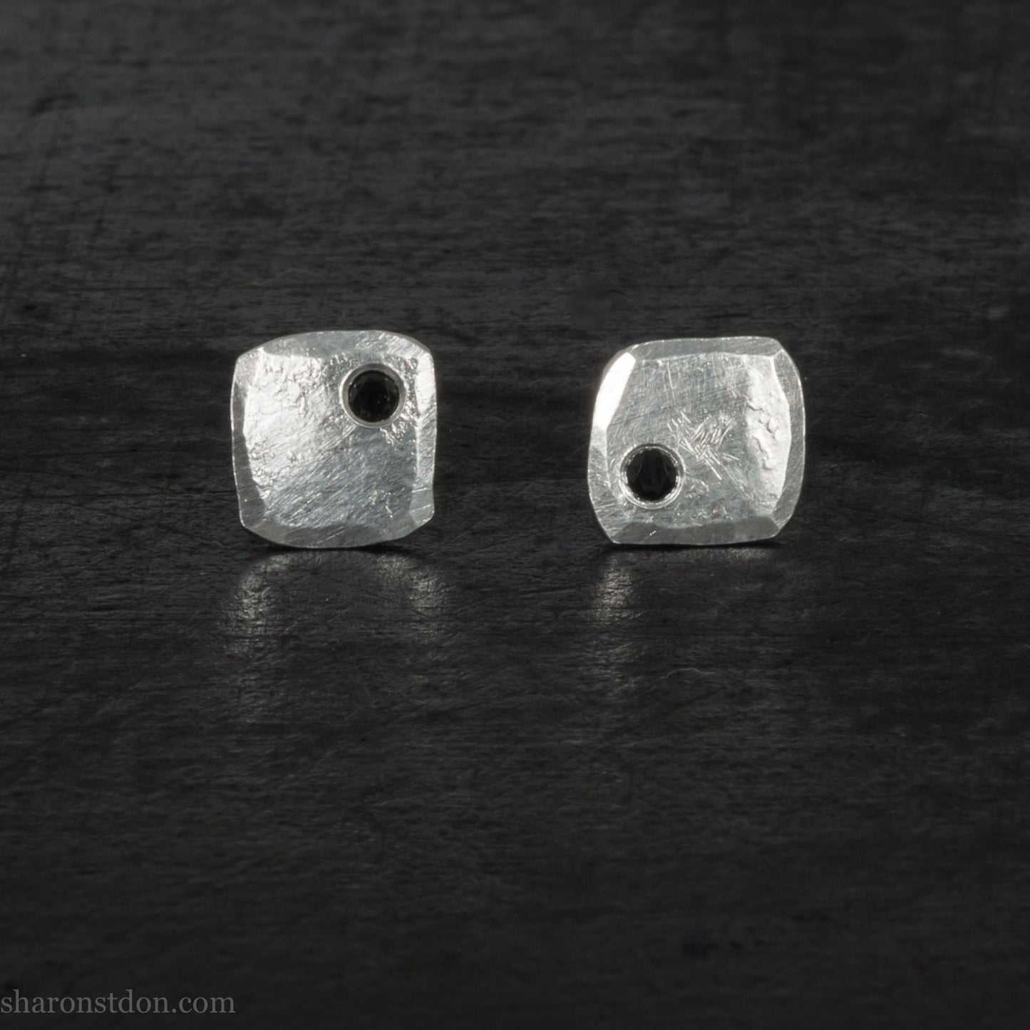 7mm square 925 sterling silver stud earrings with a black spinel gemstone in the corner. Hammered texture with a matte, brushed, shiny finish. Handmade by Sharon SaintDon in North America for men or women.