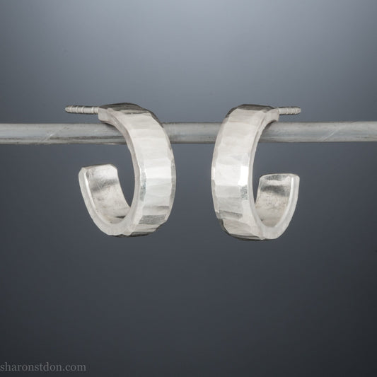 Close up photo of handcrafted 14mm x 4mm hammered solid sterling silver hoop earrings.