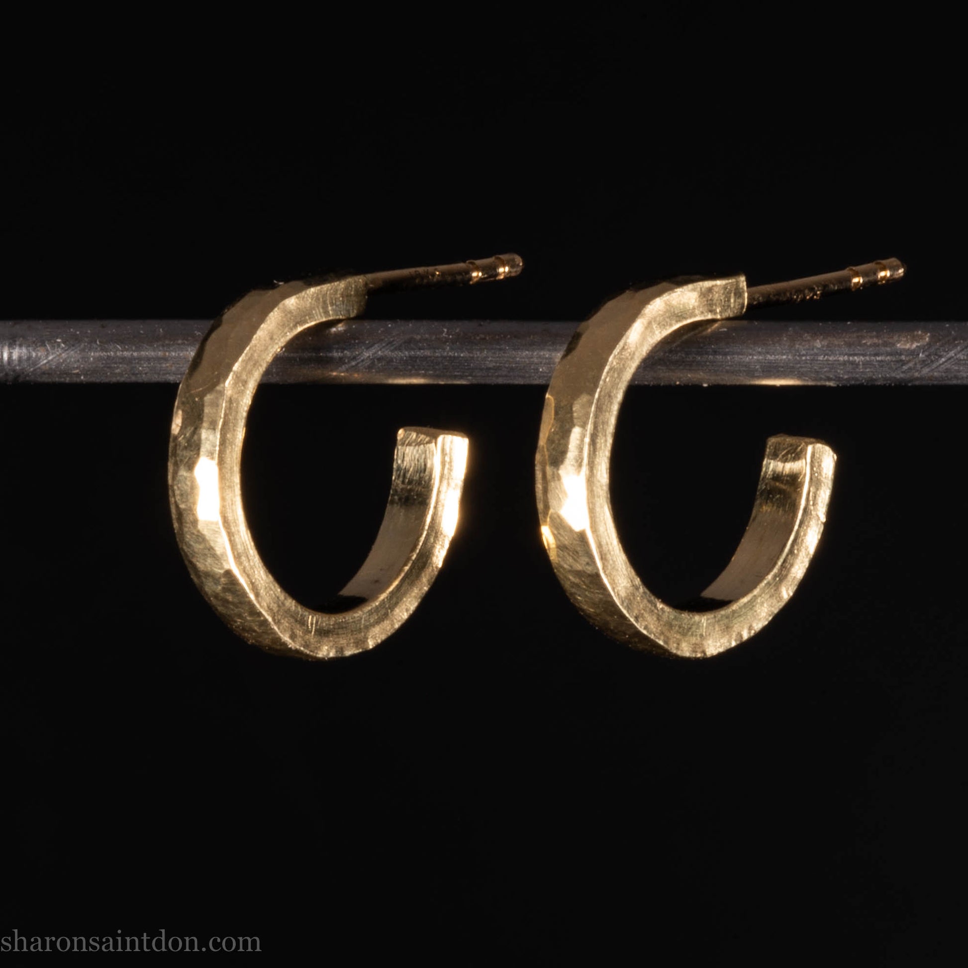 Hammered solid 18k yellow gold hoop earrings. 18mm diameter, 2mm wide, with a matte, brushed finish. Solid 18k gold posts and locking backs. Handmade by Sharon SaintDon in North America.